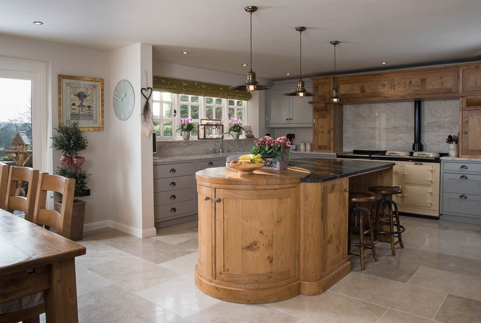 Photo of a large country u-shaped open plan kitchen in Other with a drop-in sink, beaded inset cabinets, granite benchtops, beige splashback, stone slab splashback, limestone floors and multiple islands.
