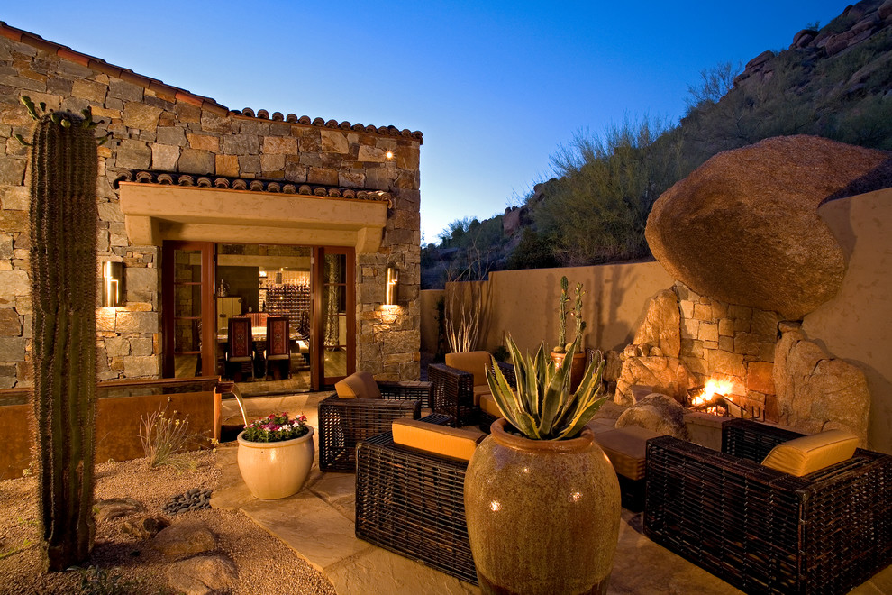 Inspiration for a mediterranean patio in Phoenix with a fire feature and no cover.