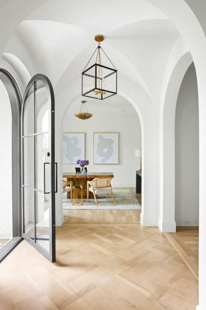 Стильный дизайн: большое фойе в стиле неоклассика (современная классика) с белыми стенами, светлым паркетным полом, одностворчатой входной дверью, металлической входной дверью и коричневым полом - последний тренд
