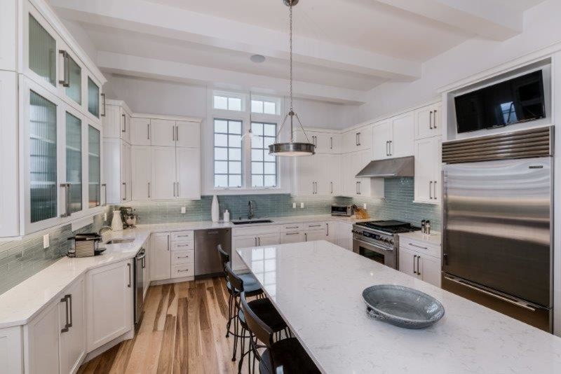 Inspiration for a large transitional u-shaped light wood floor open concept kitchen remodel with blue cabinets, quartzite countertops, blue backsplash and an island