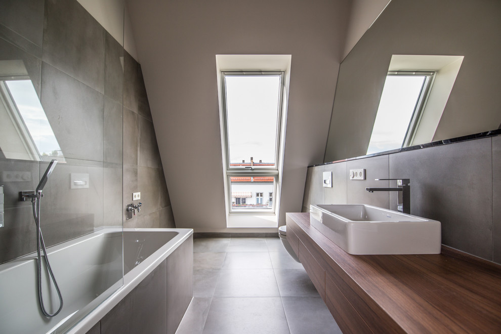 Mid-sized contemporary master bathroom in Berlin with flat-panel cabinets, a drop-in tub, brown tile, a vessel sink, wood benchtops, brown floor, medium wood cabinets, a shower/bathtub combo, brown walls and brown benchtops.