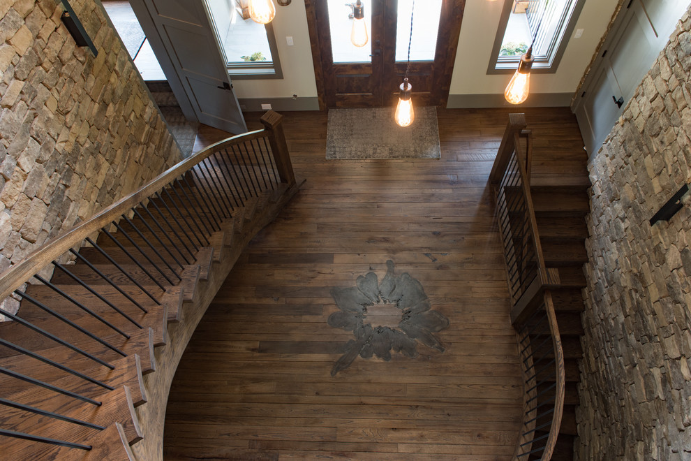 Photo of a large country wood curved staircase in Charleston with open risers and mixed railing.