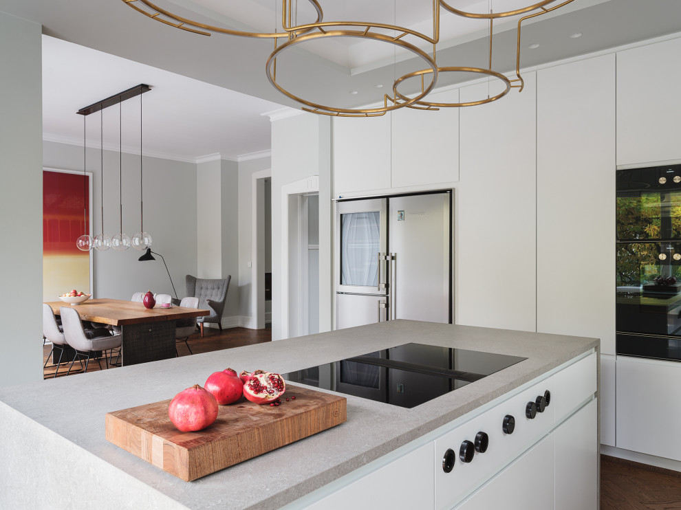 Große Moderne Küche in U-Form mit Einbauwaschbecken, flächenbündigen Schrankfronten, weißen Schränken, Mineralwerkstoff-Arbeitsplatte, Küchengeräten aus Edelstahl, Kücheninsel und grauer Arbeitsplatte in Frankfurt am Main