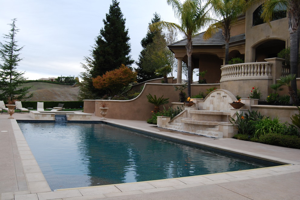 This is an example of an expansive mediterranean backyard rectangular pool in San Francisco with a hot tub and stamped concrete.
