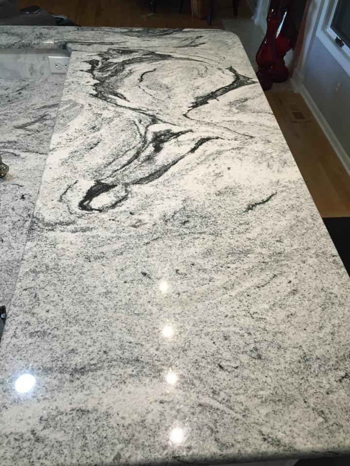 Inspiration for a mid-sized transitional u-shaped dark wood floor eat-in kitchen remodel in Detroit with an undermount sink, shaker cabinets, white cabinets, granite countertops, white backsplash, stone tile backsplash, stainless steel appliances and a peninsula
