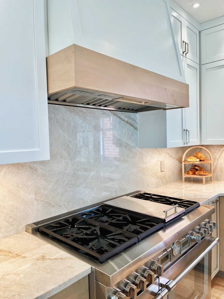 Inspiration for a large modern l-shaped light wood floor and brown floor eat-in kitchen remodel with an undermount sink, shaker cabinets, light wood cabinets, quartzite countertops, beige backsplash, stone slab backsplash, stainless steel appliances, an island and beige countertops