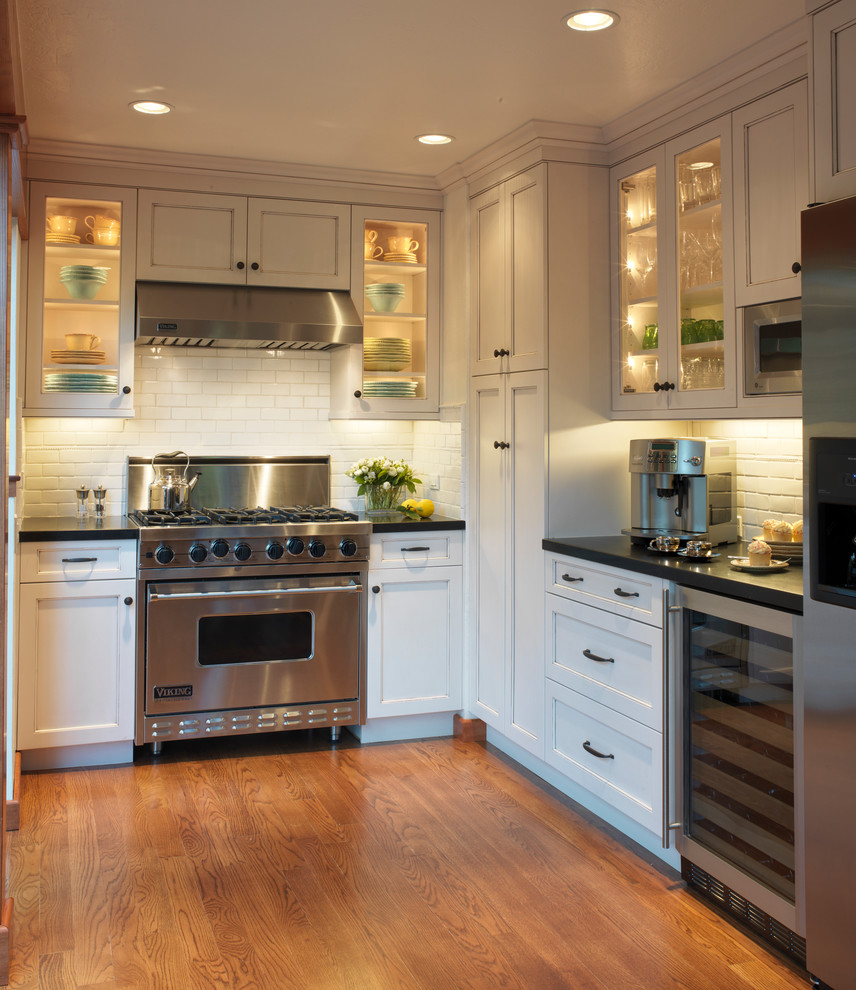 Inspiration for a traditional u-shaped separate kitchen in San Francisco with subway tile splashback, stainless steel appliances, white cabinets, white splashback and recessed-panel cabinets.