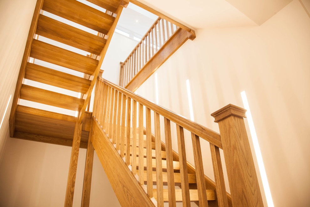 Photo of a contemporary wood u-shaped staircase in Other with wood risers and wood railing.