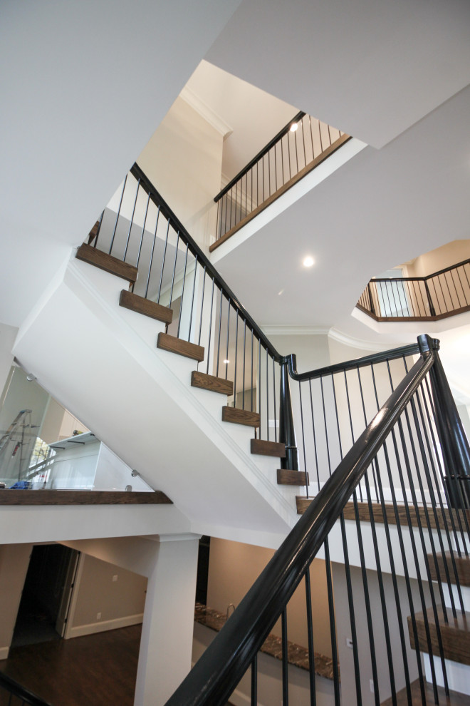 Photo of an expansive bohemian wood u-shaped mixed railing staircase in DC Metro with wood risers.