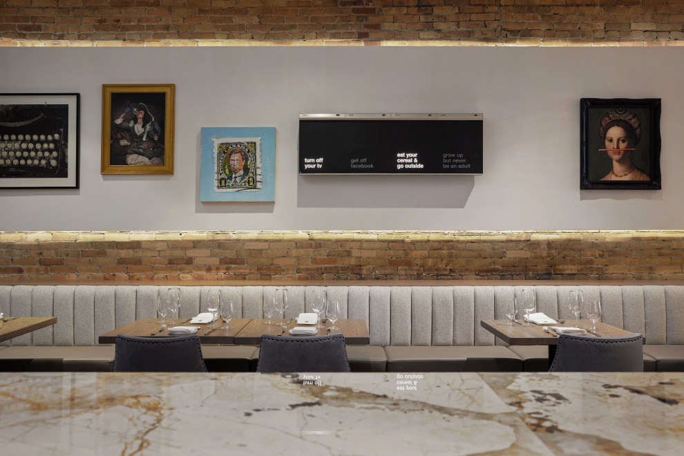 Foto di una grande sala da pranzo aperta verso la cucina tradizionale con pavimento marrone e pareti in mattoni