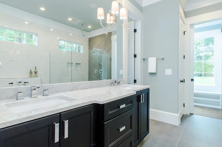 This is an example of a large transitional master bathroom in Raleigh with raised-panel cabinets, white cabinets, a freestanding tub, an open shower, a one-piece toilet, gray tile, white tile, stone tile, blue walls, marble floors, a drop-in sink, marble benchtops, white floor and an open shower.
