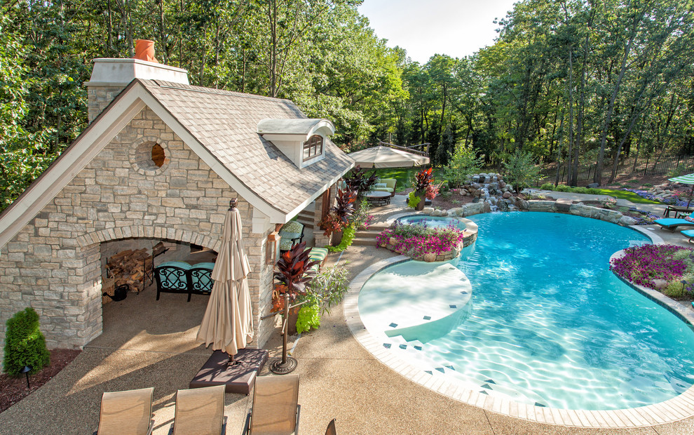Photo of a traditional kidney-shaped pool in Detroit with a pool house.
