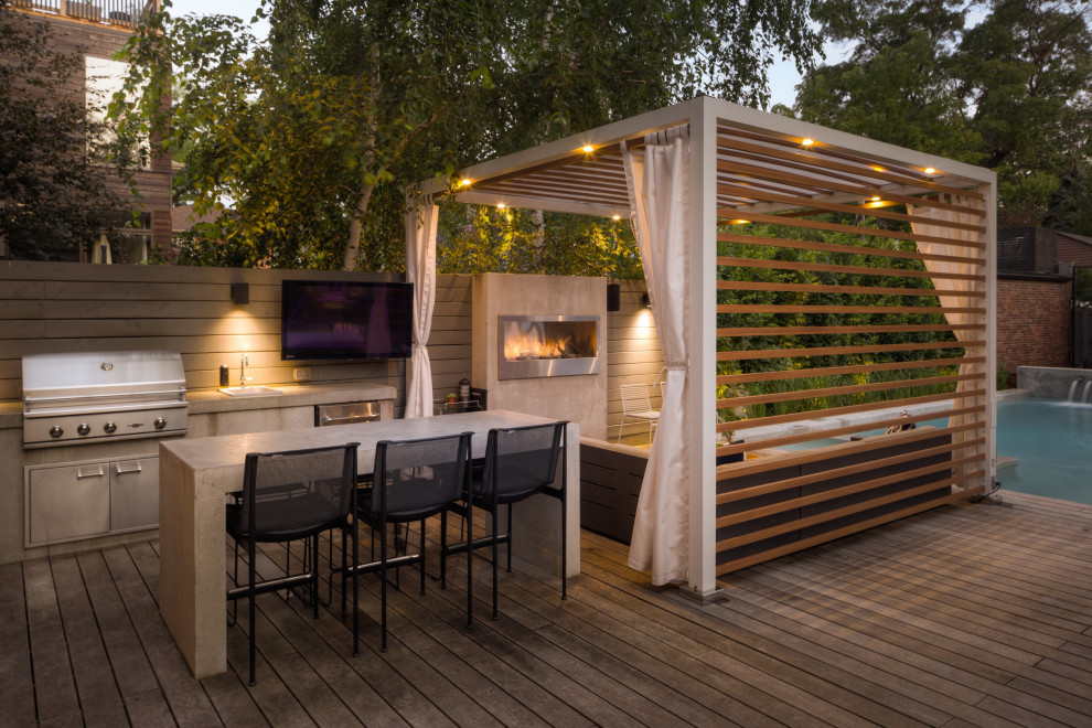 Mid-sized urban backyard ground level deck photo in Toronto with a fireplace and a pergola