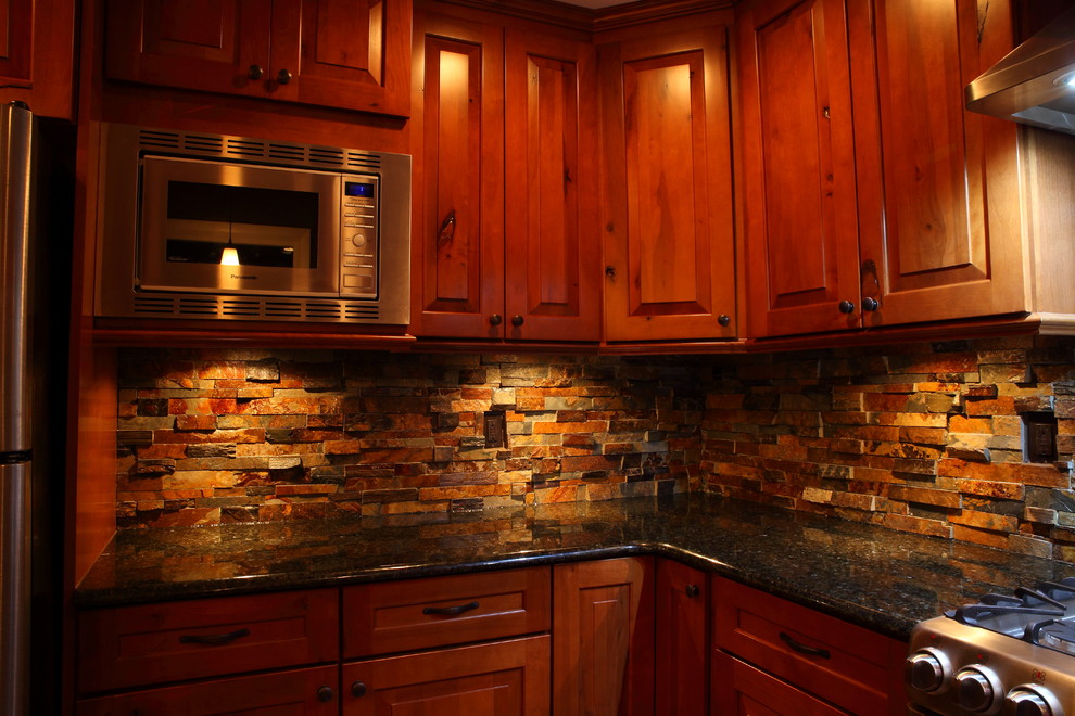 Small mountain style u-shaped eat-in kitchen photo with a single-bowl sink, raised-panel cabinets, medium tone wood cabinets, granite countertops, multicolored backsplash, stone slab backsplash, stainless steel appliances and no island