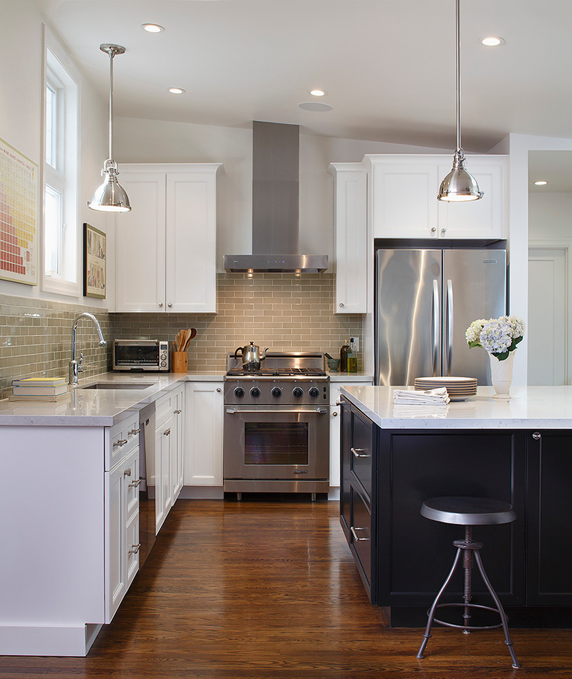 Traditional l-shaped eat-in kitchen in San Francisco with an undermount sink, shaker cabinets, white cabinets, solid surface benchtops, beige splashback, ceramic splashback and stainless steel appliances.