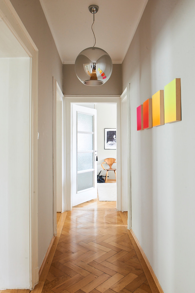 Eklektischer Flur mit grauer Wandfarbe, hellem Holzboden und beigem Boden in München