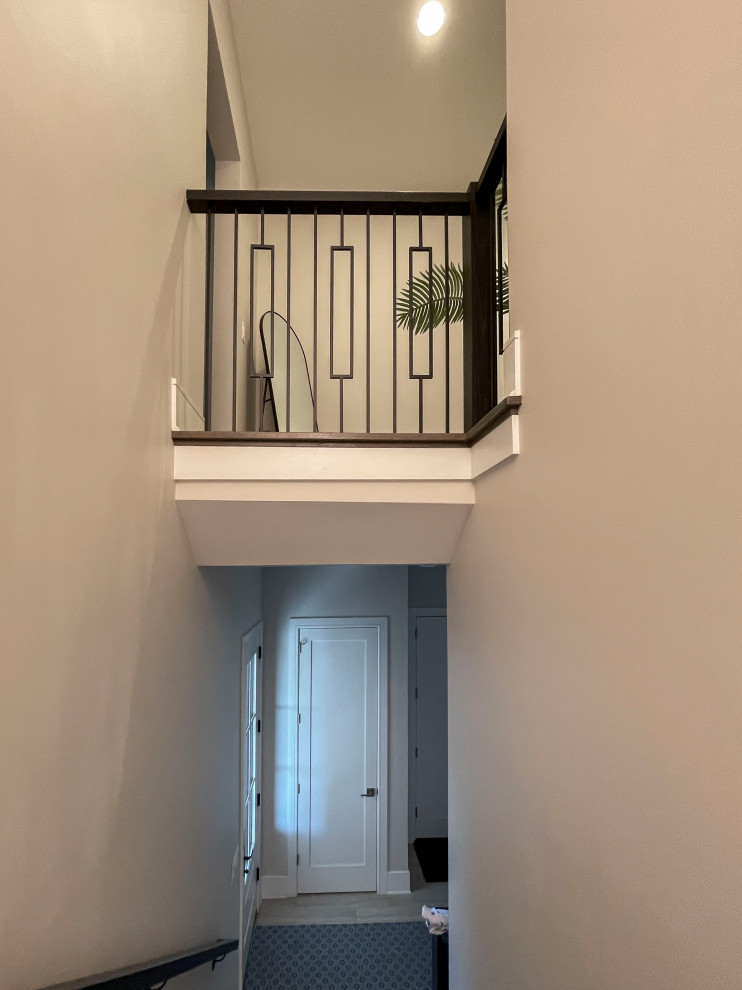 Aménagement d'un très grand escalier peint courbe classique avec des marches en bois, un garde-corps en matériaux mixtes et du papier peint.