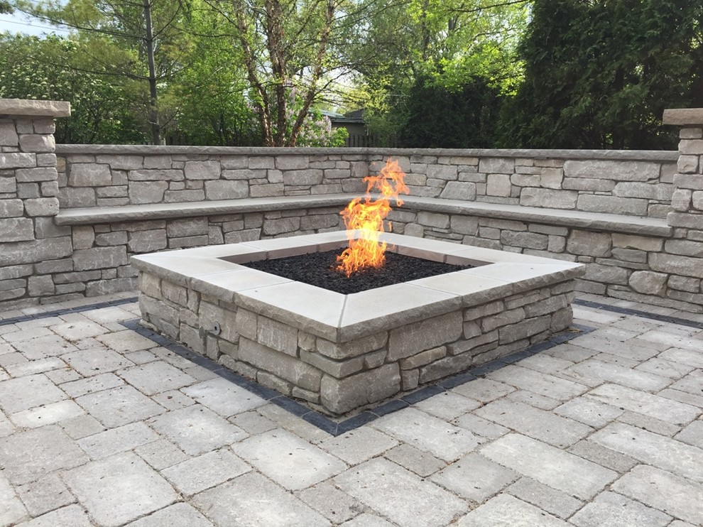Large traditional backyard patio in Chicago with a fire feature, natural stone pavers and no cover.