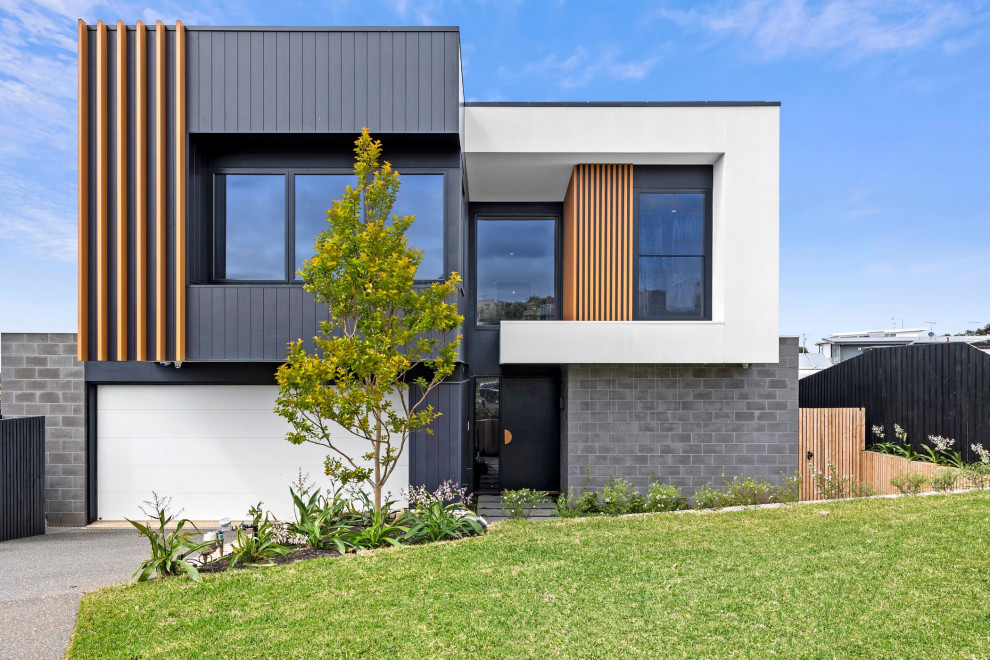 Inspiration for a large contemporary two-storey house exterior in Geelong with mixed siding and a flat roof.