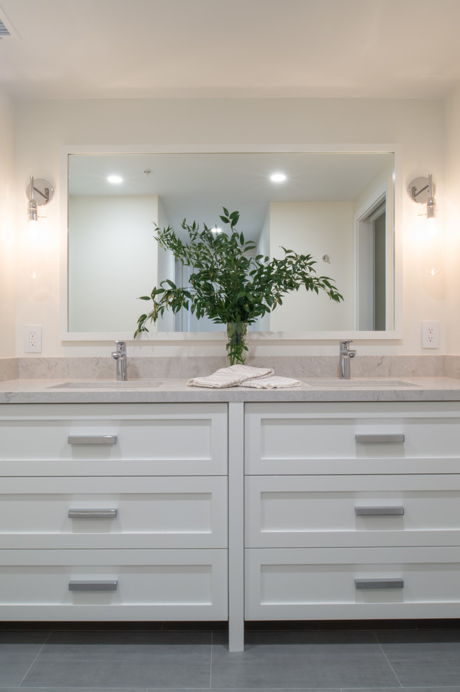 Photo of a small contemporary master bathroom in San Diego with flat-panel cabinets, white cabinets, an alcove shower, a one-piece toilet, white tile, marble, white walls, ceramic floors, an undermount sink, engineered quartz benchtops, grey floor and a hinged shower door.