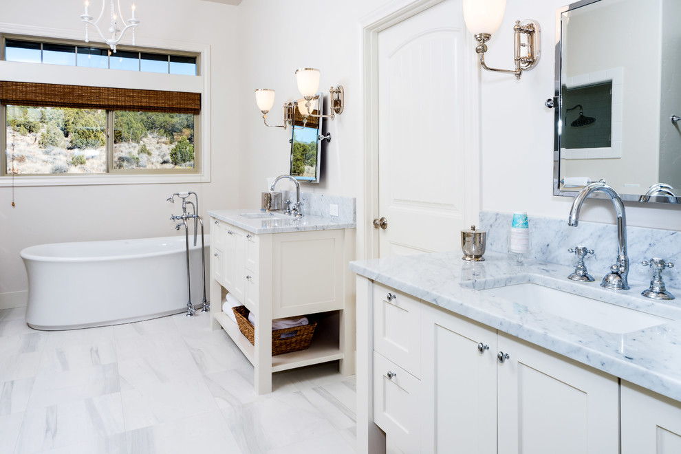 Inspiration for a large transitional master white tile and subway tile marble floor and white floor freestanding bathtub remodel with shaker cabinets, white cabinets, white walls, an undermount sink, marble countertops, a hinged shower door and white countertops