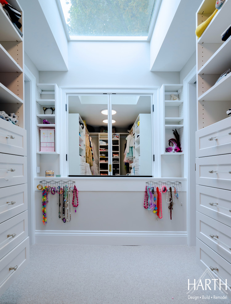 Photo of a mid-sized transitional women's walk-in wardrobe in Philadelphia with shaker cabinets, white cabinets, carpet, beige floor and vaulted.