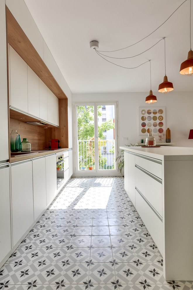Photo of a large contemporary galley open plan kitchen in Paris with a single-bowl sink, beaded inset cabinets, white cabinets, laminate benchtops, panelled appliances, cement tiles, with island, white floor and white splashback.