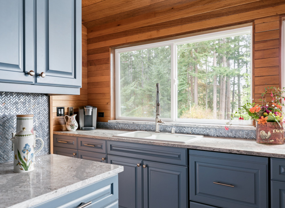 Inspiration for a large country l-shaped open plan kitchen in Seattle with an undermount sink, raised-panel cabinets, blue cabinets, quartz benchtops, blue splashback, glass tile splashback, stainless steel appliances, bamboo floors, a peninsula, brown floor, white benchtop and wood.