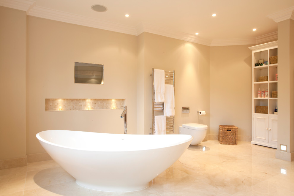 Foto på ett mellanstort funkis en-suite badrum, med ett fristående badkar, en vägghängd toalettstol, beige väggar, kalkstensgolv och gult golv
