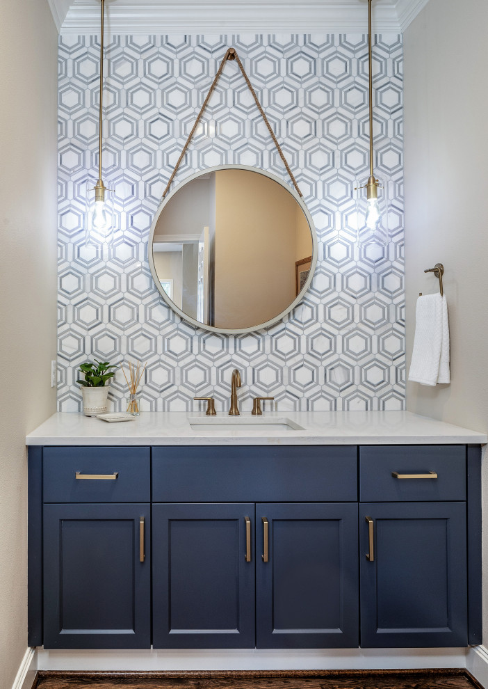Photo of a small beach style powder room in Seattle with shaker cabinets, blue cabinets, white tile, marble, grey walls, medium hardwood floors, an undermount sink, engineered quartz benchtops, brown floor and white benchtops.
