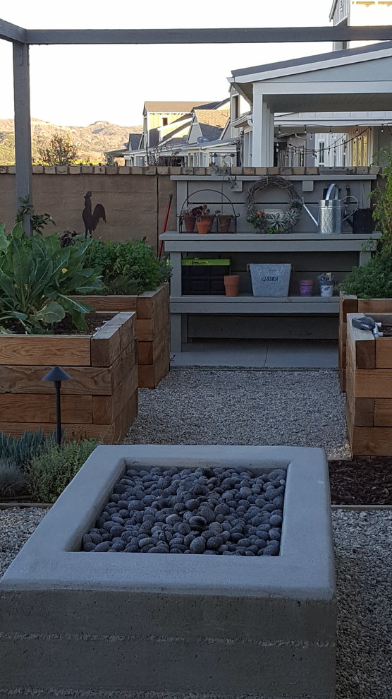 Small country backyard full sun xeriscape in Los Angeles with a vegetable garden and concrete pavers.