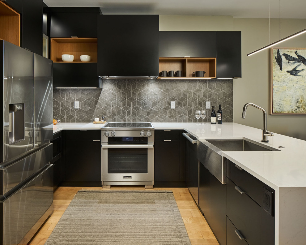 Inspiration for a small contemporary u-shaped light wood floor and brown floor eat-in kitchen remodel in Portland with an undermount sink, flat-panel cabinets, black cabinets, quartz countertops, gray backsplash, porcelain backsplash, stainless steel appliances, no island and white countertops