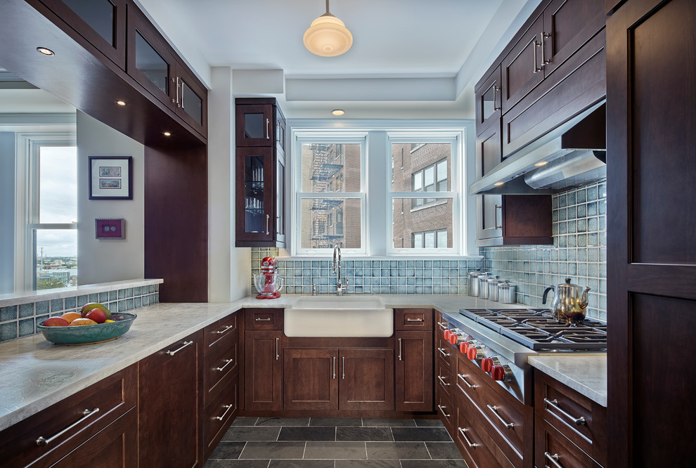 This is an example of a mid-sized transitional u-shaped separate kitchen in Chicago with a farmhouse sink, flat-panel cabinets, dark wood cabinets, quartzite benchtops, blue splashback, ceramic splashback, stainless steel appliances, slate floors, no island and grey floor.