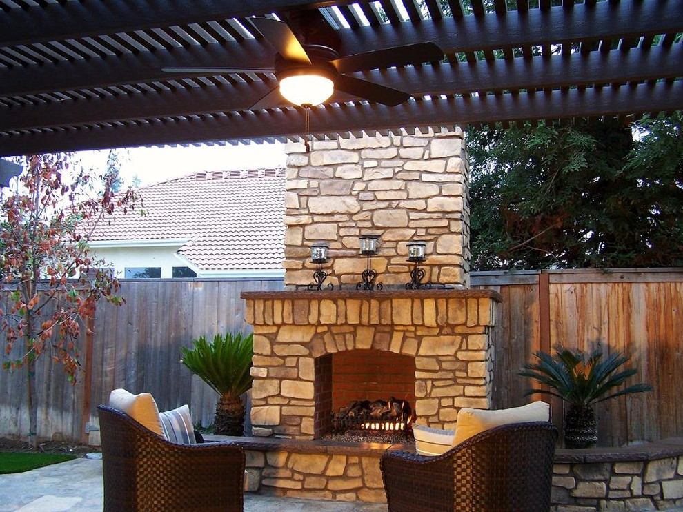 Design ideas for a mid-sized mediterranean backyard patio in Other with a fire feature and natural stone pavers.