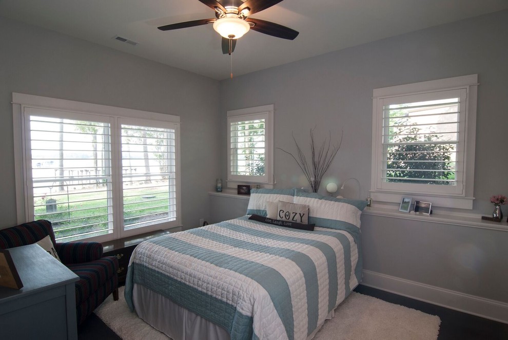 This is an example of a large transitional guest bedroom in Charlotte with grey walls, dark hardwood floors, no fireplace and brown floor.