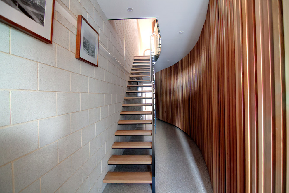 Mid-sized contemporary wood straight staircase in Other with open risers and glass railing.