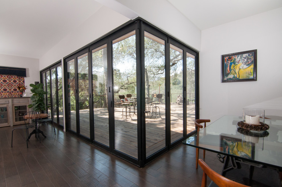 This is an example of an expansive contemporary eat-in kitchen in Los Angeles with glass-front cabinets, light wood cabinets, dark hardwood floors and with island.