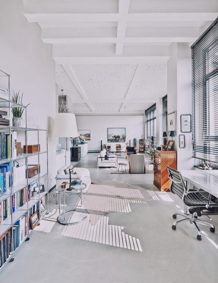 Photo of an expansive contemporary loft-style living room in Berlin with a library, white walls, concrete floors and grey floor.