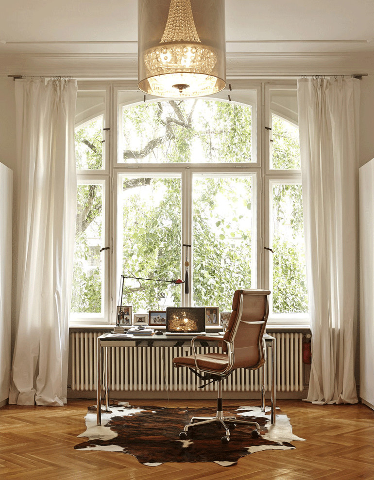 Inspiration for a large contemporary study room in Berlin with a freestanding desk, white walls, no fireplace and medium hardwood floors.