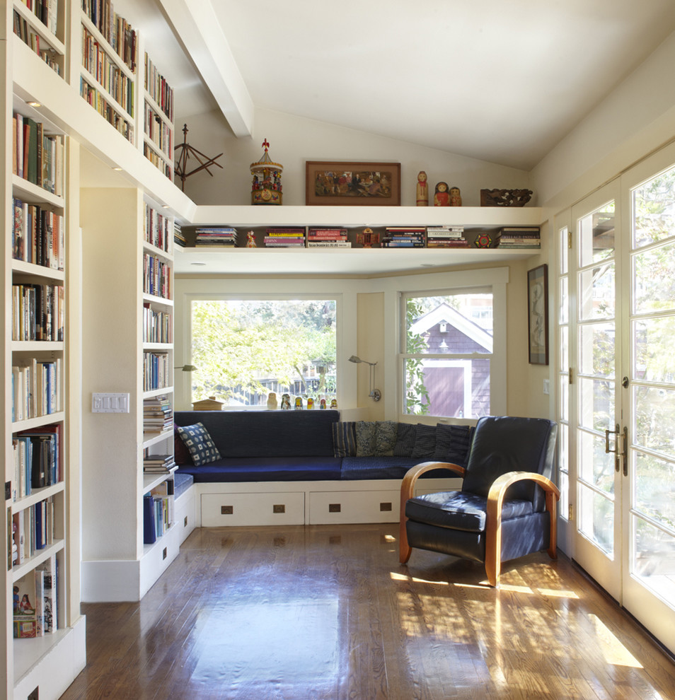 This is an example of a mid-sized contemporary enclosed family room in San Francisco with a library, white walls and medium hardwood floors.