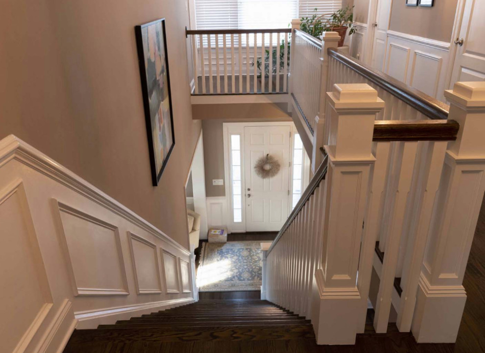 This is an example of a mid-sized transitional wood straight staircase in New York with wood railing and painted wood risers.