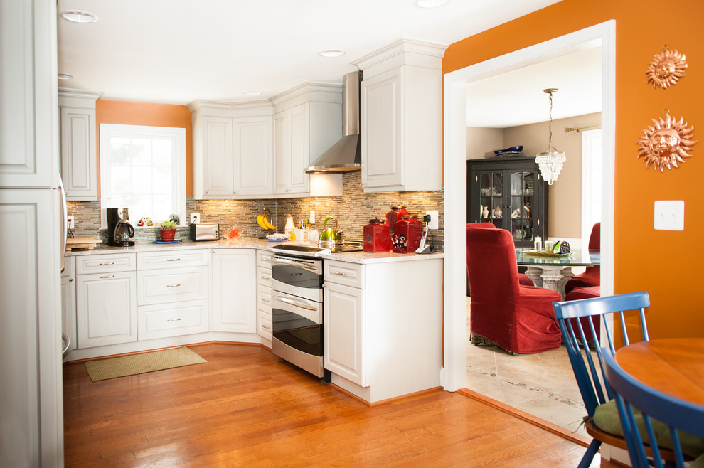 Inspiration for a mid-sized transitional u-shaped medium tone wood floor eat-in kitchen remodel in DC Metro with raised-panel cabinets, white cabinets, quartzite countertops, multicolored backsplash, matchstick tile backsplash, stainless steel appliances, no island and an undermount sink