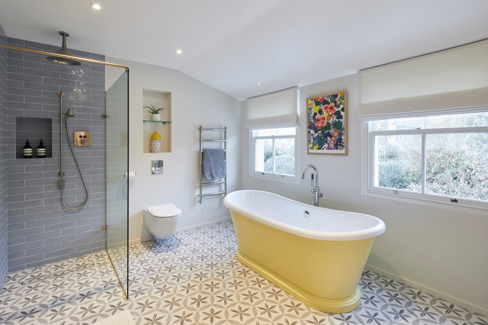 Design ideas for a large contemporary grey and yellow family bathroom in London with white cabinets, a freestanding bath, a walk-in shower, a wall mounted toilet, blue tiles, an integrated sink, an open shower, double sinks and a floating vanity unit.