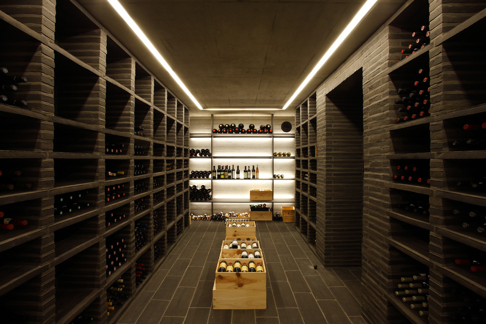 Photo of a large contemporary wine cellar in Hamburg with storage racks and slate floors.