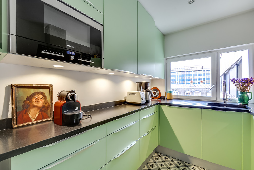 Photo of a mid-sized contemporary u-shaped separate kitchen in Paris with an integrated sink, flat-panel cabinets, green cabinets, granite benchtops, white splashback, ceramic floors and no island.