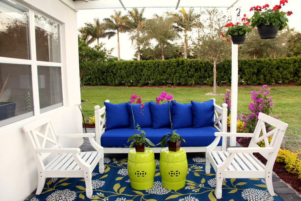 Inspiration for a small beach style backyard patio in Miami with a pergola and brick pavers.