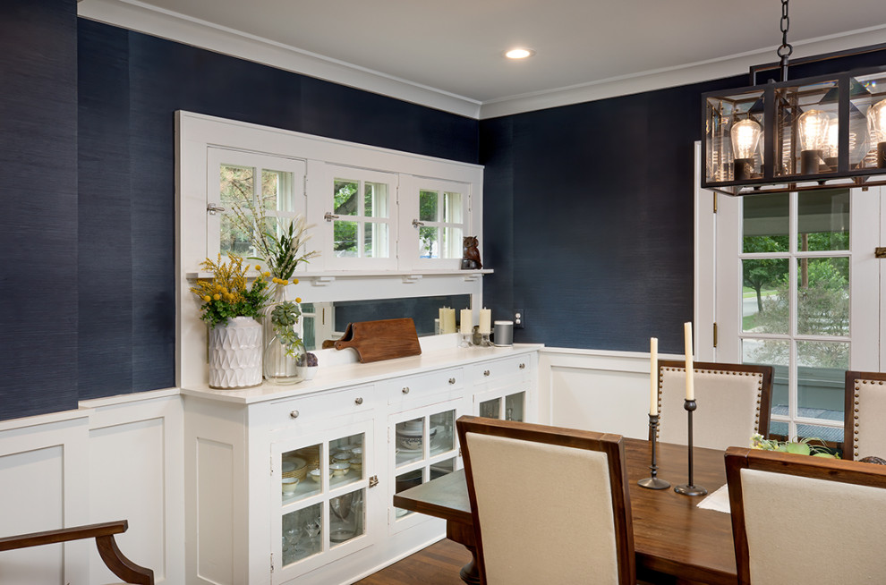 Photo of a transitional separate dining room in Columbus with blue walls, dark hardwood floors, brown floor and wallpaper.