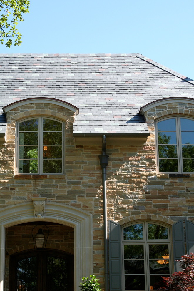 Inspiration for a large traditional two-storey beige exterior in Dallas with stone veneer and a hip roof.
