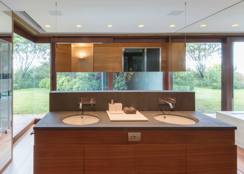 Cette image montre une très grande salle de bain principale minimaliste en bois brun avec du carrelage en marbre, parquet clair, un lavabo intégré et meuble double vasque.