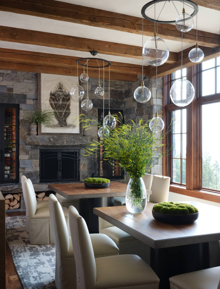 Inspiration for a rustic exposed beam dining room remodel with a standard fireplace and a stone fireplace